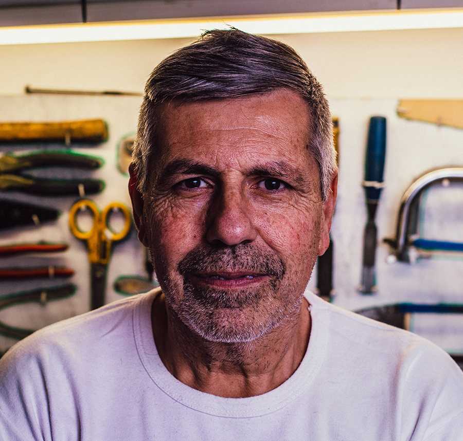 An elderly man with rough stubble stares at the camera