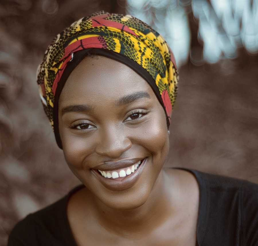 A young African-Australian woman smiles at the camera.