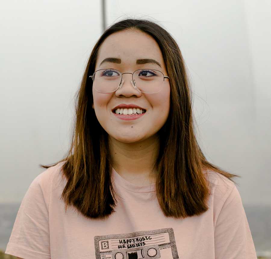 A young Asian woman with glasses looks off to the side