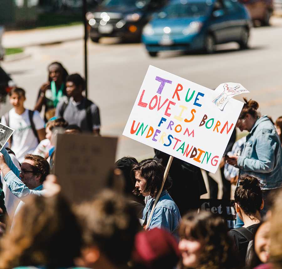 A protester holds up a colourful sign which reads: 'True love is born from understanding'