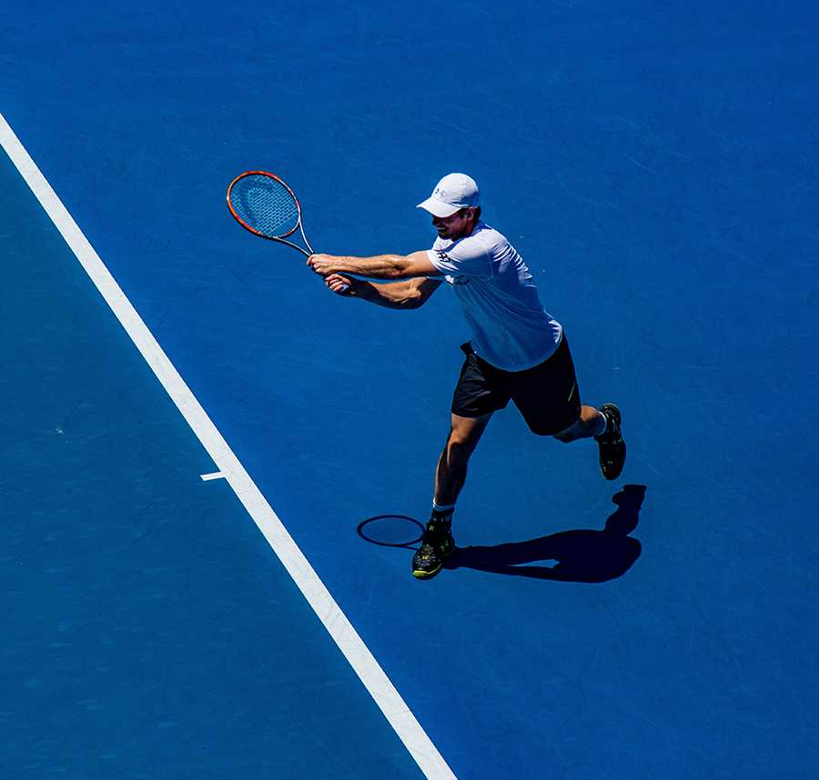 A male tennis player hits a backhand at the Australian Open.